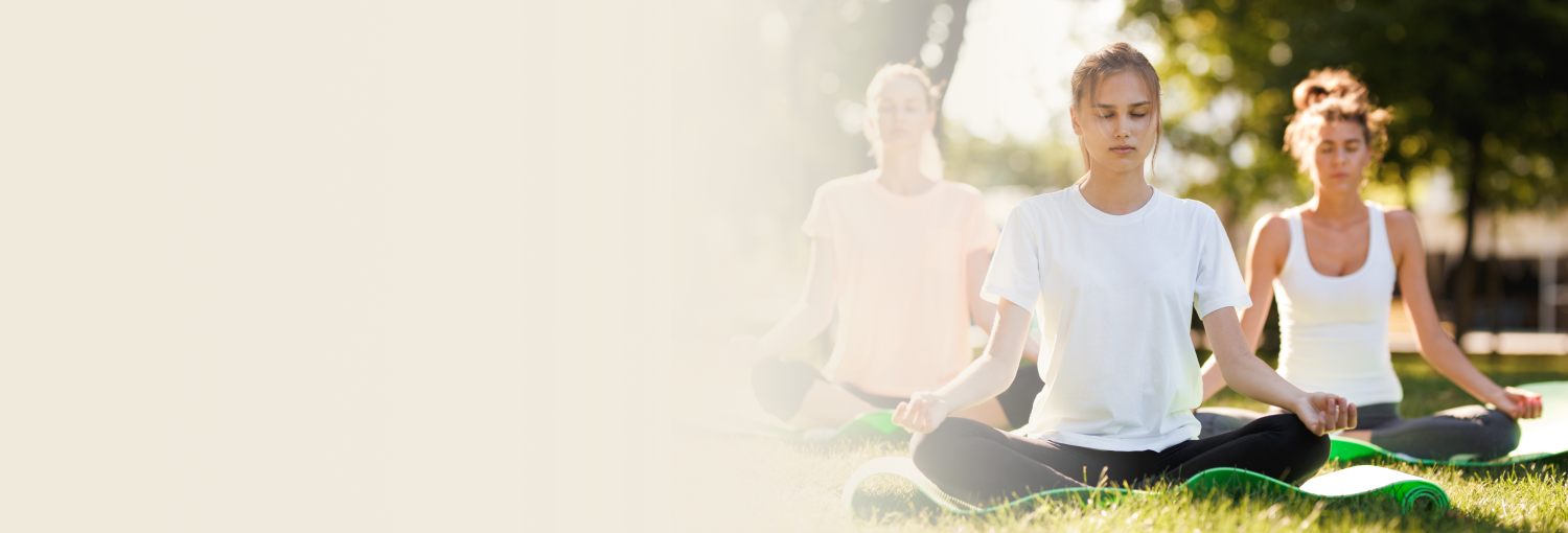 People practicing meditation in lotus pose during sunset