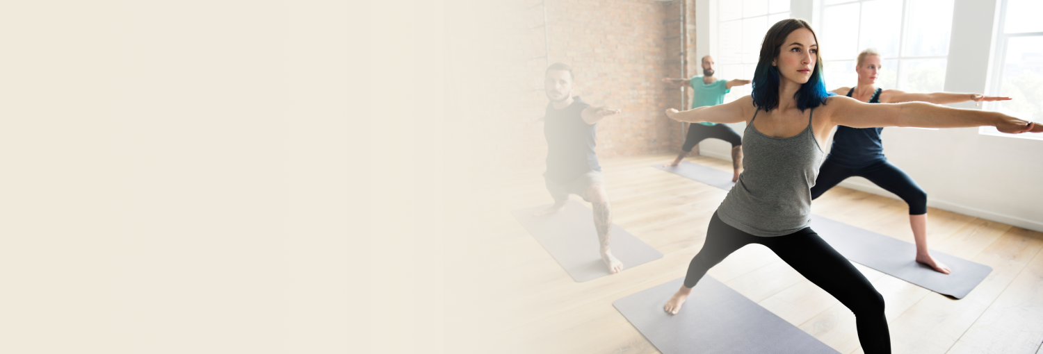 Group practicing warrior pose during sri sri yoga course