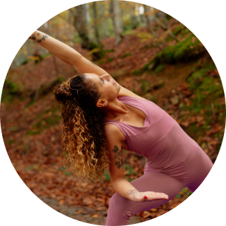 A woman practicing a yoga pose in a serene forest setting, illustrating the connection between nature and yoga in the Sri Sri Yoga course