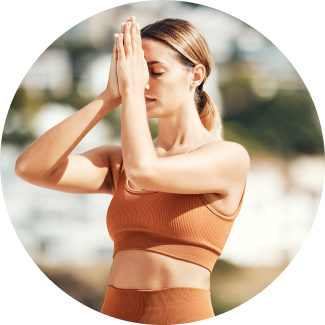 A woman practicing a focused pose with hands at the heart center, reflecting the principles of breath and balance in Sri Sri Yoga