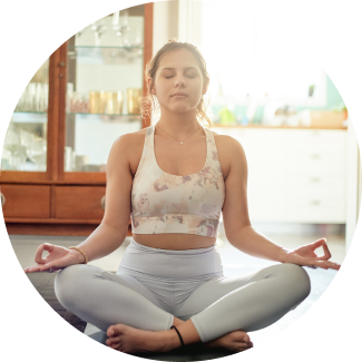 A woman meditating in a tranquil indoor space, embodying the mindfulness and serenity promoted in Sri Sri Yoga
